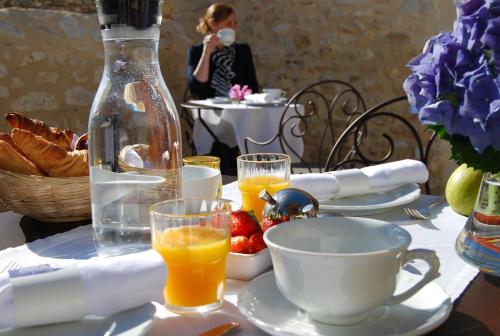 a woman taking a picture of a table with orange juice at Château Hôtel Edward 1er in Monpazier