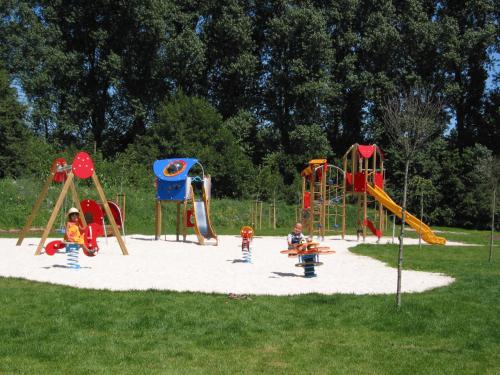 eine Gruppe von Kindern, die auf einem Spielplatz spielen in der Unterkunft Haus am See - Gochness in Kessel