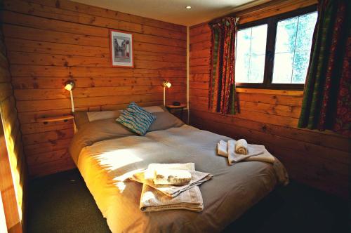 een slaapkamer met een bed met handdoeken erop bij La Coterie Lodges in Blaudeix