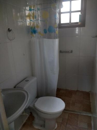 a bathroom with a white toilet and a sink at cantinho do yuji in Cabo Frio