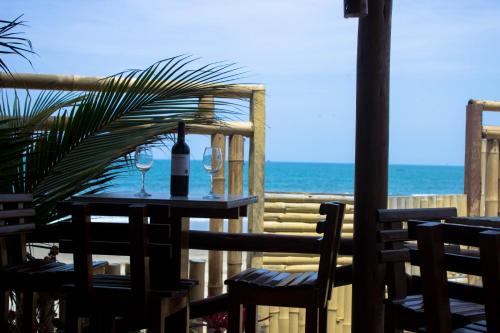 a table with a bottle of wine and two glasses at Maria Jose Bungalows in Zorritos