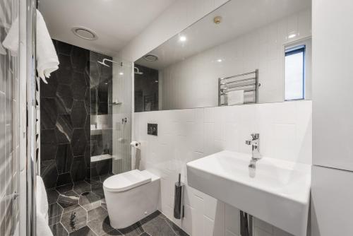 a white bathroom with a toilet and a sink at Elk at Falls in Falls Creek