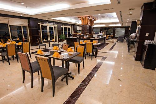 a dining room with tables and chairs in a restaurant at Swiss-Belhotel Papua in Jayapura