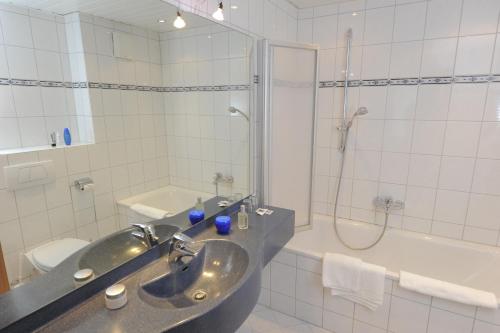 a bathroom with a sink and a shower and a tub at Appart-Hotel-Heldt in Bremen