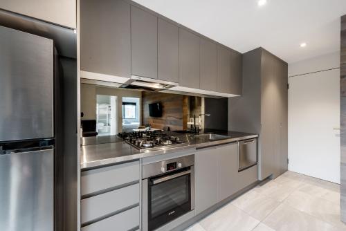 a kitchen with gray cabinets and a stove top oven at Elk at Falls in Falls Creek