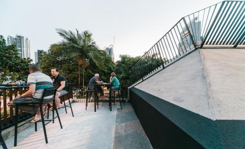 a group of people sitting at tables on a patio at Lloyd's Inn in Singapore