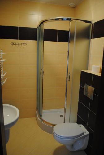 a bathroom with a shower with a toilet and a sink at Krzywy Domek w Ostrowie Morza Brzeg in Ostrowo