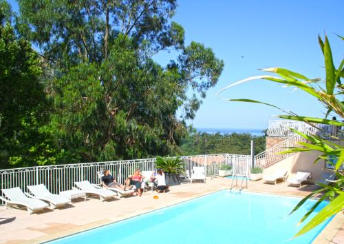 un grupo de personas sentadas alrededor de una piscina en Capo D'orto - Porto - Corse, en Porto Ota