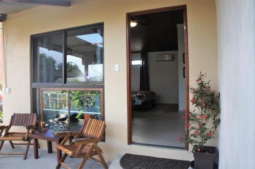 a house with two chairs and a glass door at Casa Donna Rosa B&B in Nuevo Arenal