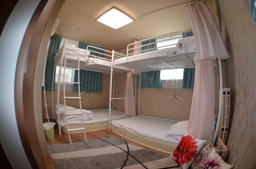 a room with three bunk beds in it at Fukuoka Guest House Jikka in Fukuoka