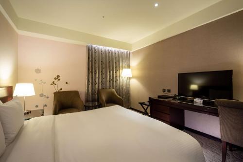 a hotel room with a bed and a flat screen tv at 雀客旅館台中來來 in Taichung