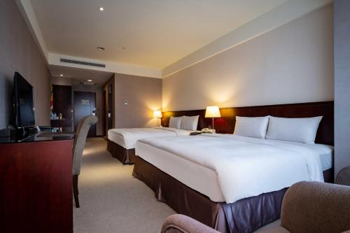 a hotel room with two beds and a television at 雀客旅館台中來來 in Taichung