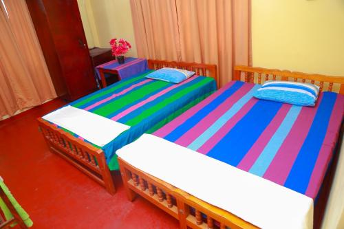 a bedroom with two beds with colorful sheets at Lucullus Garden in Bentota