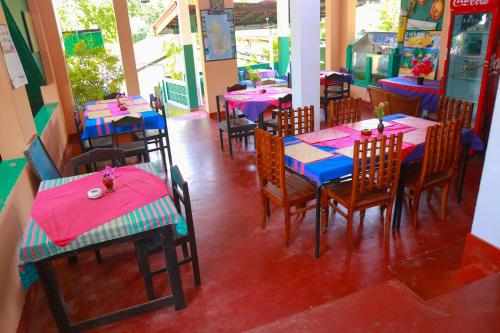 a restaurant with pink and blue tables and chairs at Lucullus Garden in Bentota
