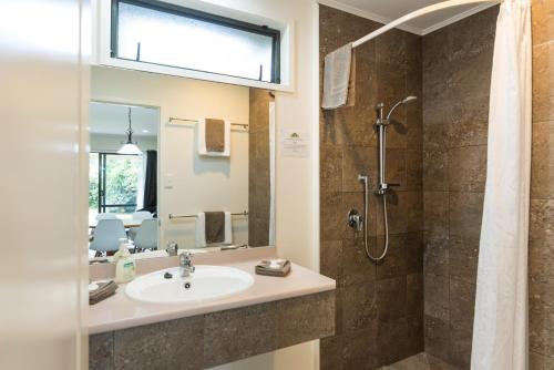 a bathroom with a sink and a shower at Kauri Park Motel in Kerikeri