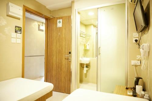 a small room with a bed and a bathroom at Hoo Sang Hostel 香港豪生酒店 in Hong Kong