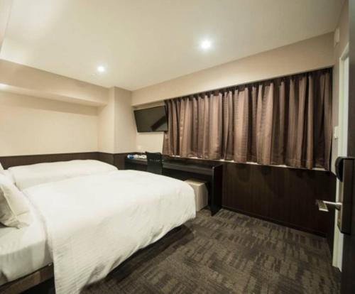 a hotel room with a bed and a window at Hotel Excellence Kyoto Station Nishi in Kyoto