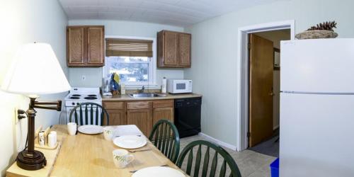 a kitchen with a table with chairs and a refrigerator at Gauthier's Saranac Lake Inn in Saranac Lake