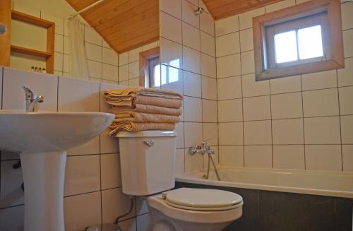 a bathroom with a toilet and a sink and a tub at Palafito Azul Apart Hotel in Castro