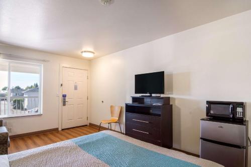 a bedroom with a bed and a tv and a microwave at Motel 6 Portland Mall - 205 in Portland