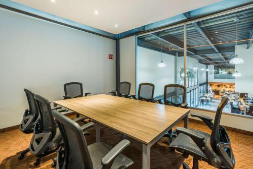 a conference room with a wooden table and chairs at Wyndham Garden Guadalajara Expo Plaza del Sol in Guadalajara