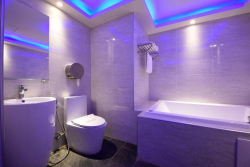 y baño con bañera, aseo y lavamanos. en Meng Siang Motel en Pingzhen
