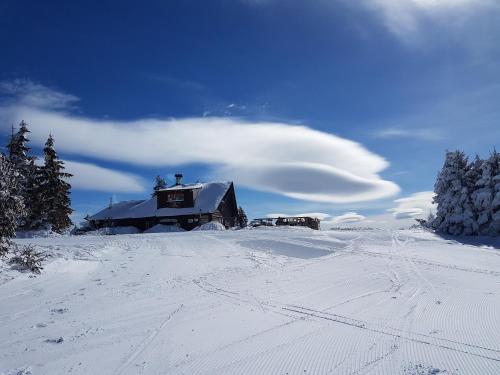 a house in the snow with a cloud above it at Milmari M18 Kopaonik in Kopaonik