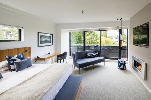 a living room filled with furniture and a large window at Queenstown Park Boutique Hotel in Queenstown