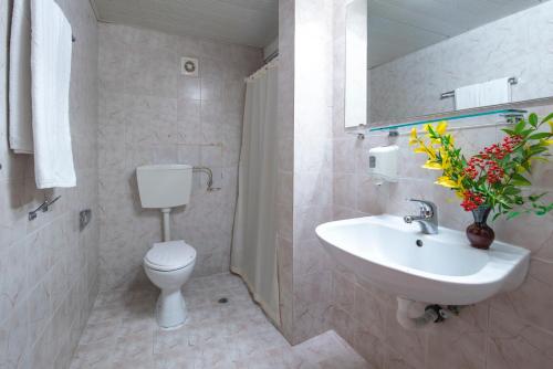 een badkamer met een wastafel, een toilet en een spiegel bij Hotel Iskar & Aquapark - Premium All Inclusive in Sunny Beach