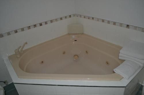 a bath tub with two towels in a bathroom at Colonial Lodge Motel in Taupo