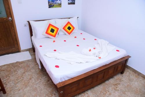 a bed with two pillows on it in a room at White Villa Airport Transit Hotel in Katunayake