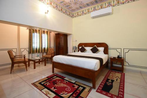 a bedroom with a king sized bed and a living room at Virasat Mahal Heritage Hotel in Jaipur