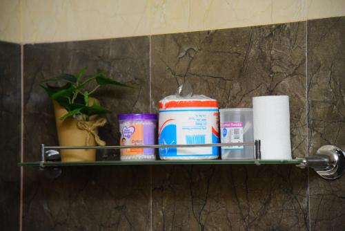a shelf in a bathroom with toiletries on it at White Villa Airport Transit Hotel in Katunayake