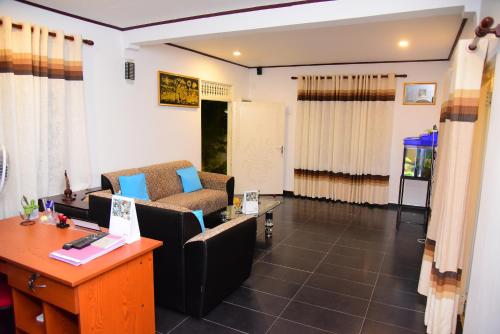a living room with a couch and a desk at White Villa Airport Transit Hotel in Katunayake