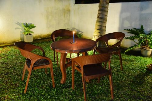 a table and chairs with a candle on it at White Villa Airport Transit Hotel in Katunayake