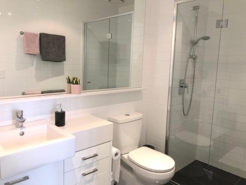 La salle de bains est pourvue de toilettes, d'un lavabo et d'une douche. dans l'établissement EPIC Private Apartment, à Melbourne