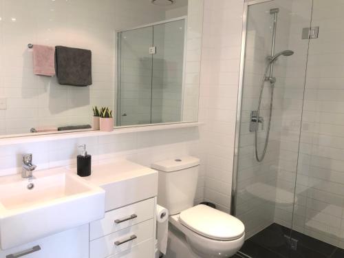 メルボルンにあるEPIC Private Apartmentのトイレ、洗面台、シャワー付きのバスルーム