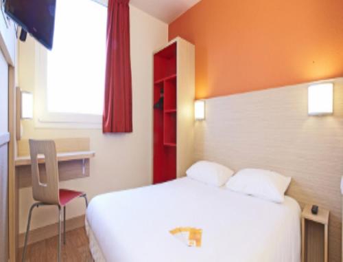 - une chambre avec un lit, une chaise et une fenêtre dans l'établissement Premiere Classe Saint Etienne - Aéroport Bouthéon, à Andrézieux-Bouthéon