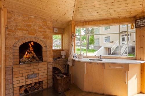 a kitchen with a fireplace in a tiny house at Amber Coast & Sea in Jūrmala