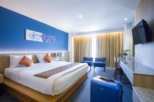 a hotel room with a large bed and a blue wall at Royal Palace Hotel in Pattaya Central