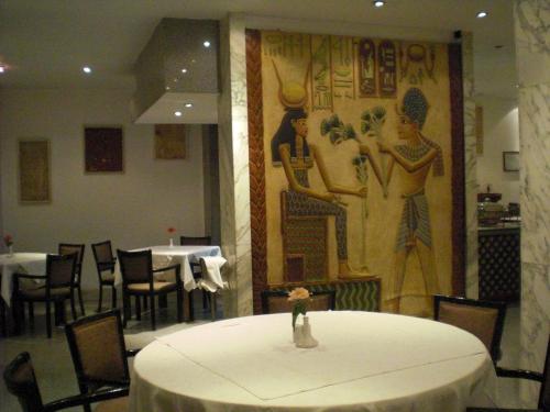 a table in a restaurant with a painting on the wall at Philippe Luxor Hotel in Luxor