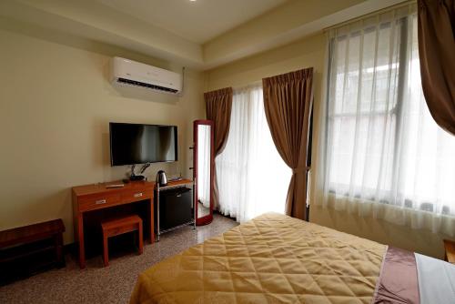 Hongfu Elegant Business Hotel في تشونغلي: غرفة فندقية بسرير وتلفزيون بشاشة مسطحة