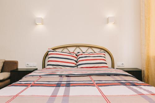 a bedroom with a bed with a striped bedspread at Apart-Hotel in Sumy