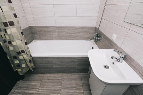 a bathroom with a bath tub and a sink at Apart-Hotel in Sumy