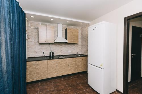 a kitchen with a sink and a refrigerator at Apart-Hotel in Sumy