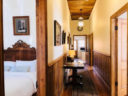 a bedroom with a bed and a table in it at Ned Kelly’s Marlo Cottage - in the best Beechworth location in Beechworth