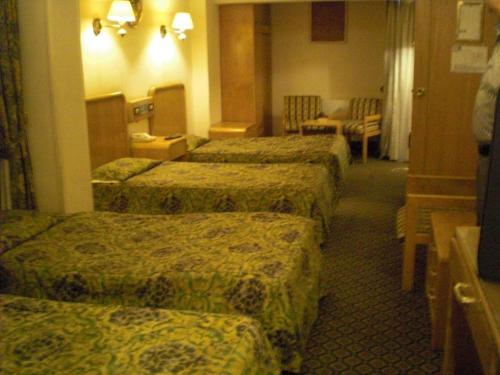 a hotel room with four beds in a room at Philippe Luxor Hotel in Luxor