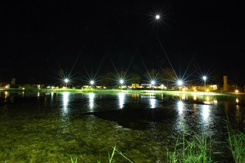 a nightime view of a lake with lights at Lapa Lange Game Lodge in Mariental