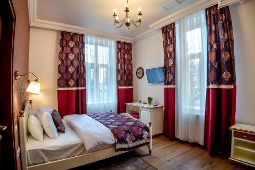 a bedroom with red curtains and a bed and a chandelier at Ana Boutique in Alba Iulia