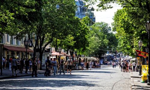 a crowd of people walking down a city street at Rose d'Opera Hotel in Odesa